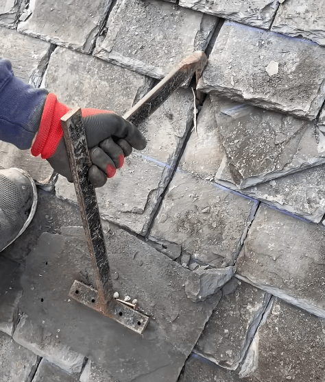 Roofer repairing cracked slate roof tiles in Stoke-on-Trent. Roofers in Stoke-on-Trent
